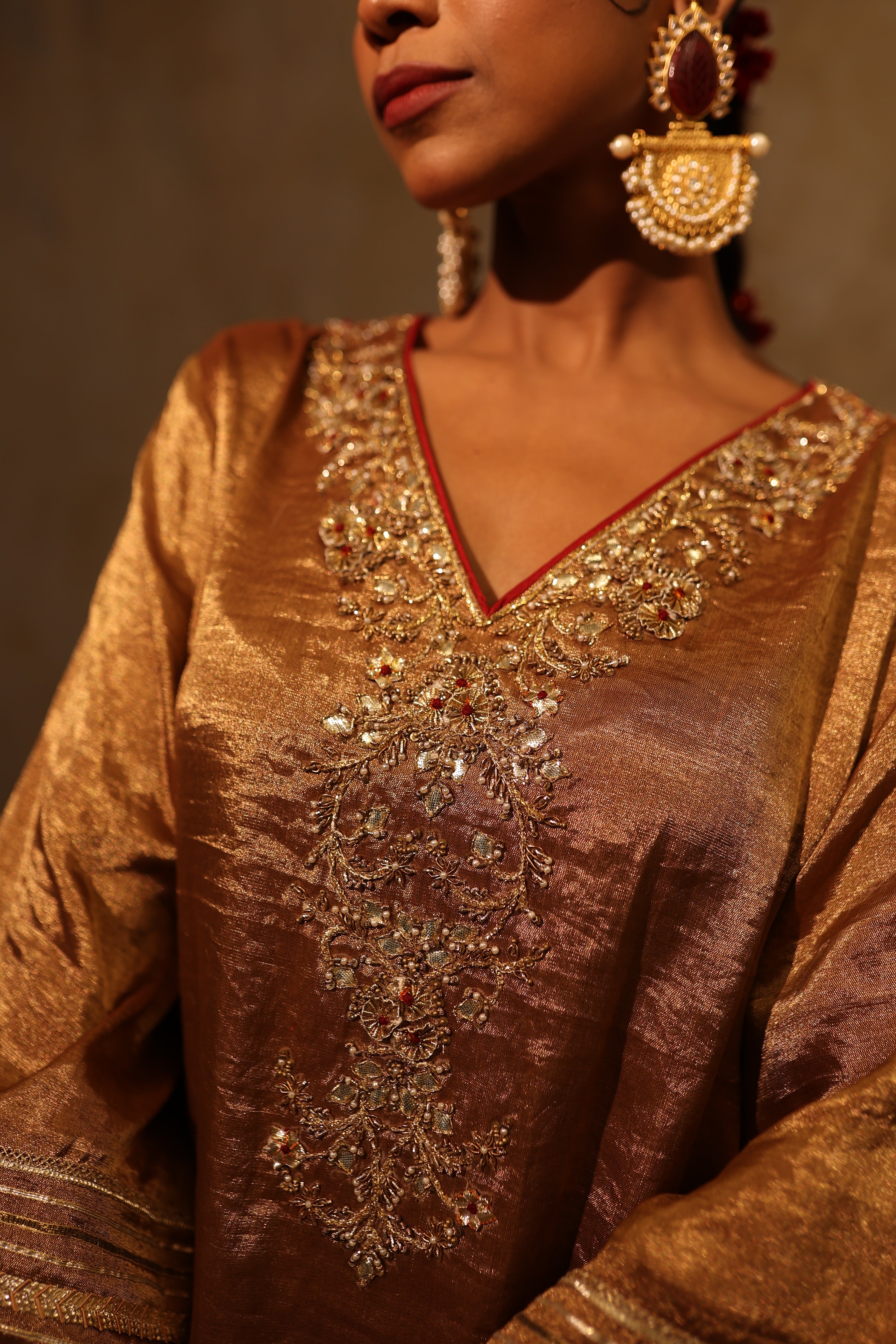 Antique gold silk tissue kurta set with intricate gota, resham, bead and dabka embroidery, paired with a red dupatta – festive women’s outfit
