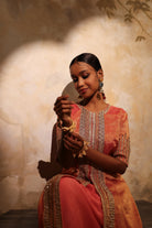 Luxury coral pink silk tissue kurta set with hand embroidery and matching pants.