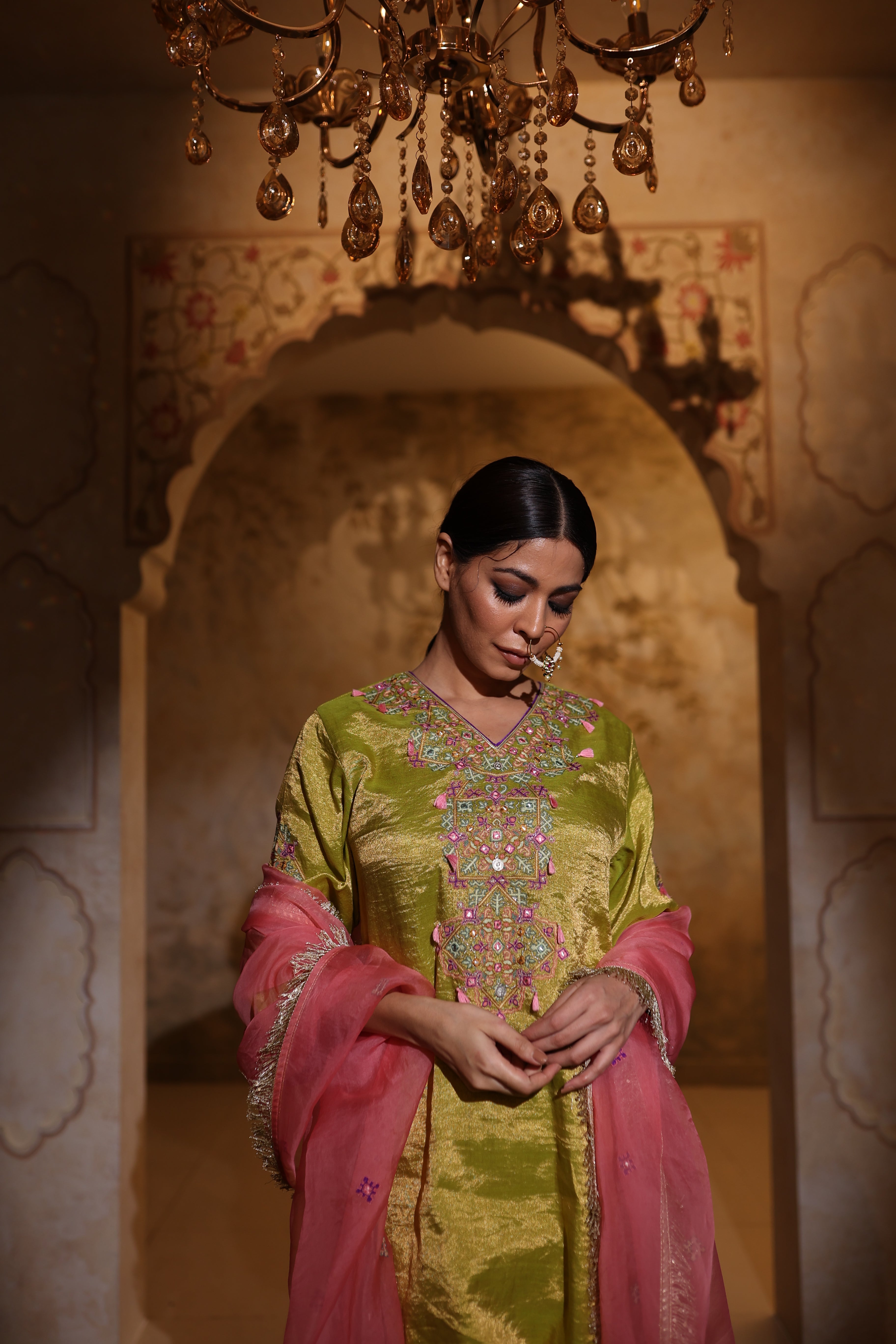 Woman in an embroidered green tisue kurta and pink organza dupatta traditional outfit perfect for festive wear or a trousseau from Shayari collection of House of AAS.