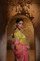 Woman in an embroidered green tisue kurta and pink organza dupatta traditional outfit perfect for festive wear or a trousseau from Shayari collection of House of AAS.