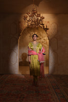Woman in an embroidered green tisue kurta and pink organza dupatta traditional outfit perfect for festive wear or a trousseau from Shayari collection of House of AAS.
