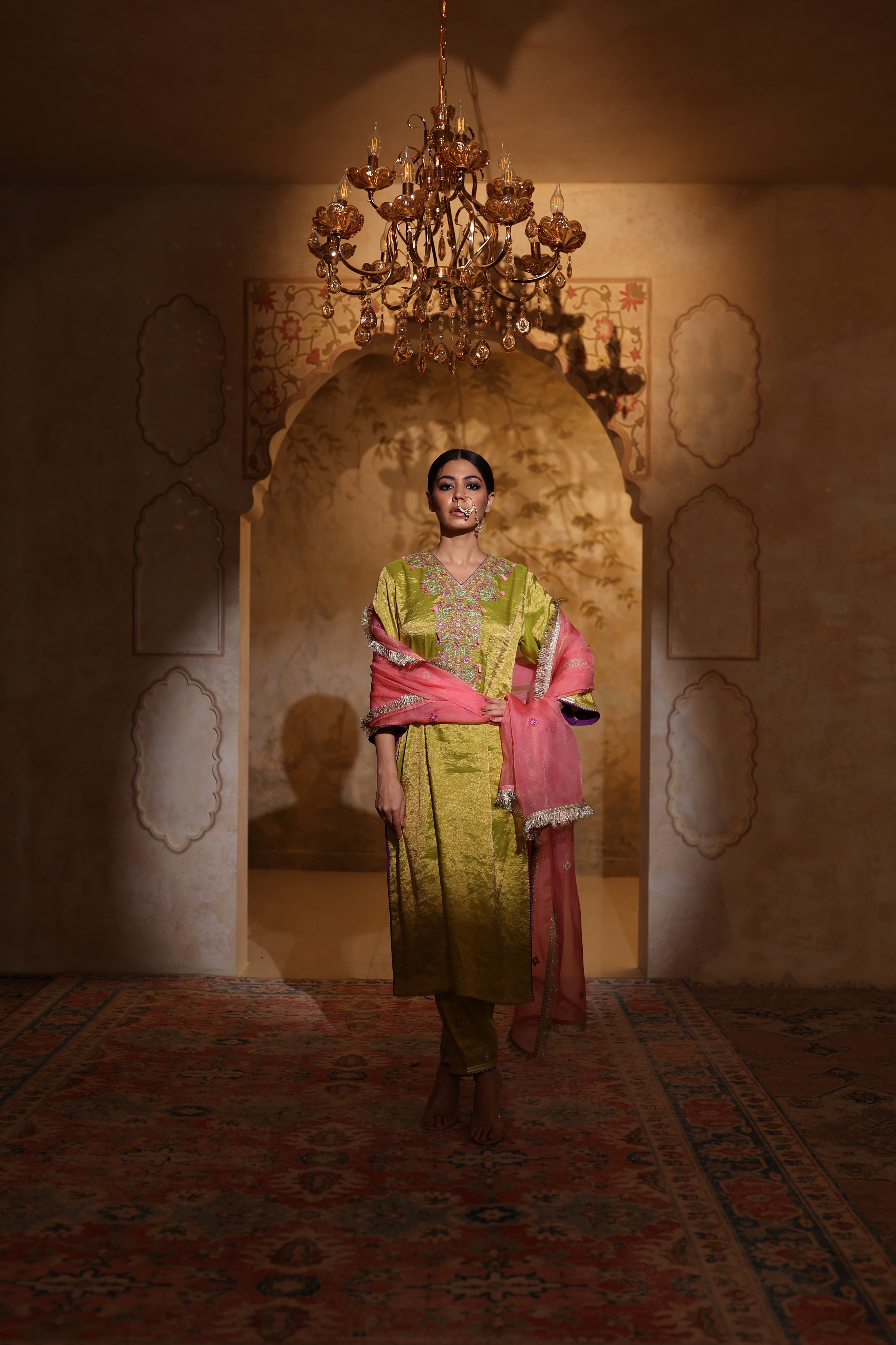 Woman in an embroidered green tisue kurta and pink organza dupatta traditional outfit perfect for festive wear or a trousseau from Shayari collection of House of AAS.
