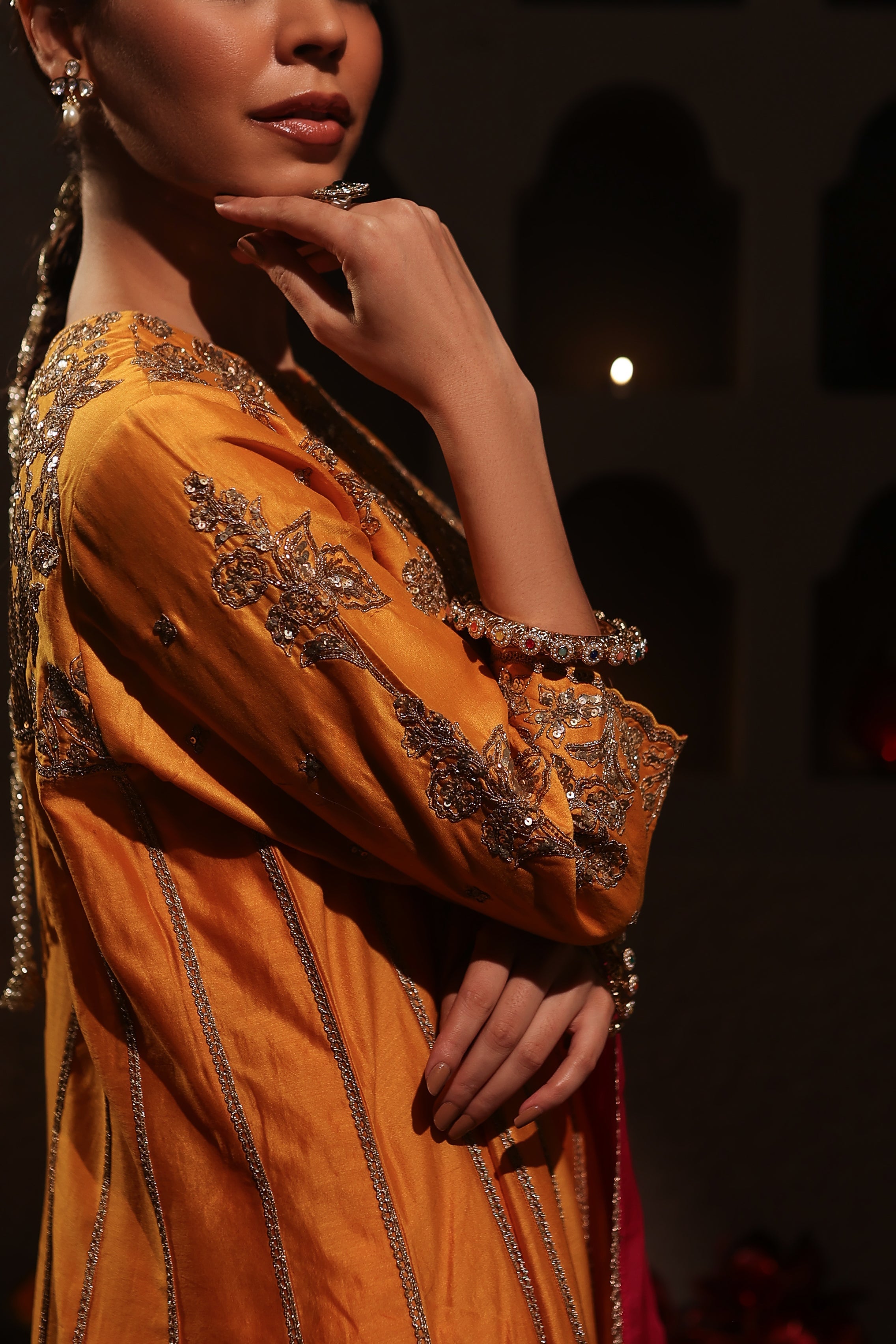 Model wearing an orange silk chanderi kurta set with pink dupatta, adorned with gold zari hand embroidery — festive wedding outfit.