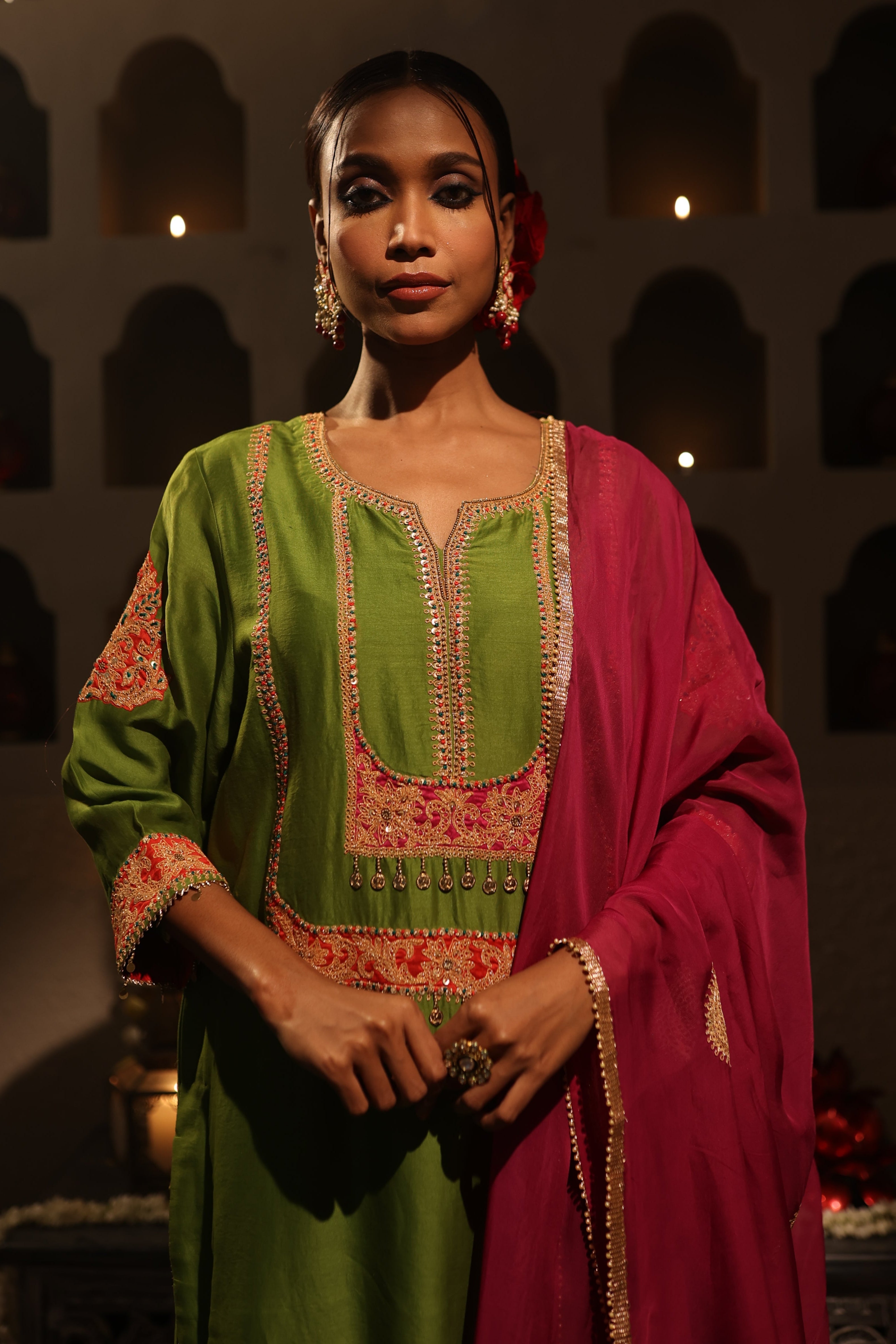 Model wearing a green silk chanderi kurta set with pink dupatta, featuring gold zari aari taari hand embroidery — festive ethnic outfit.