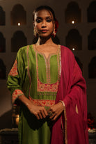Model wearing a green silk chanderi kurta set with pink dupatta, featuring gold zari aari taari hand embroidery — festive ethnic outfit.