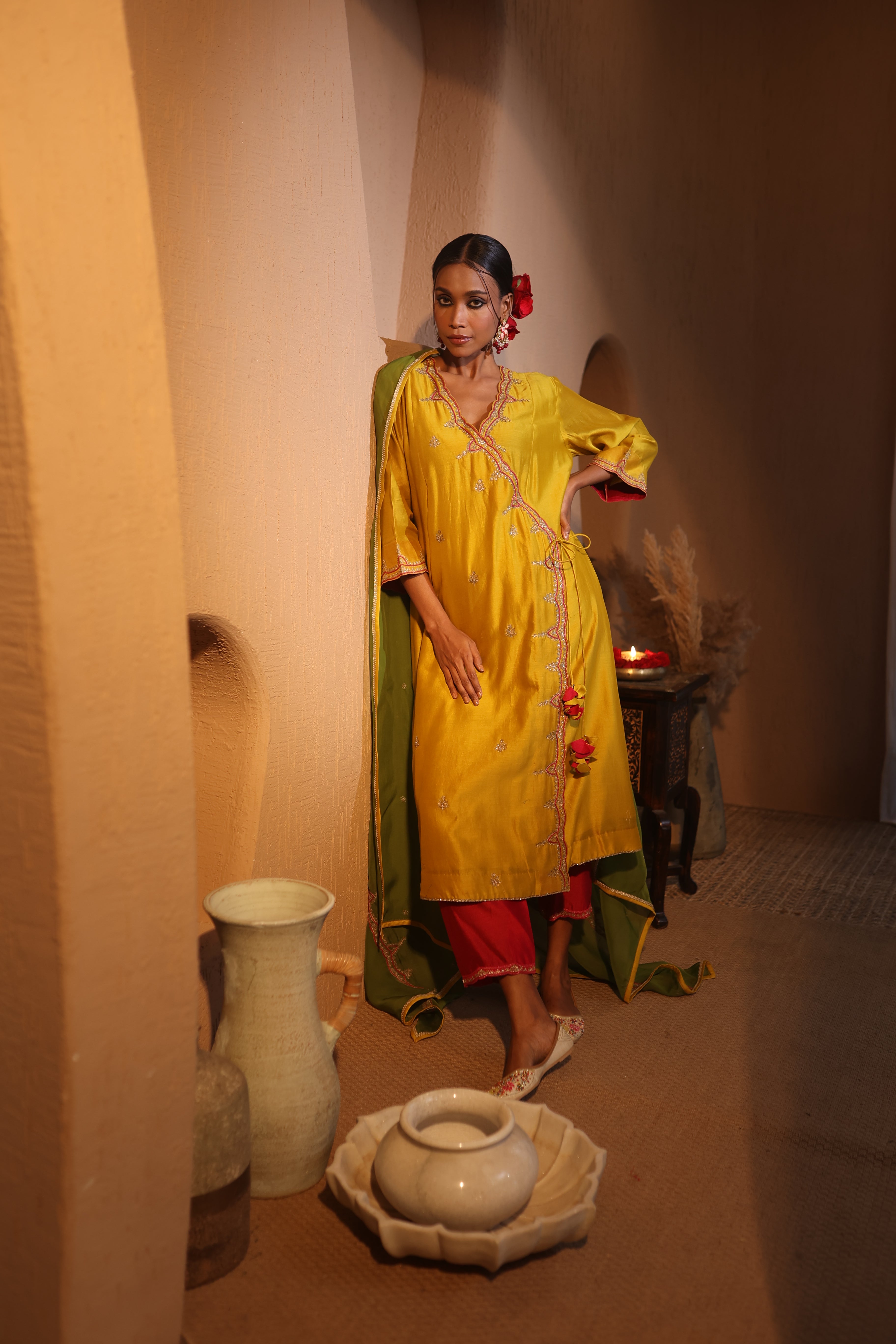 Model wearing a yellow silk chanderi kurta set with green dupatta, red pants, and tassel embroidery — festive ethnic outfit.