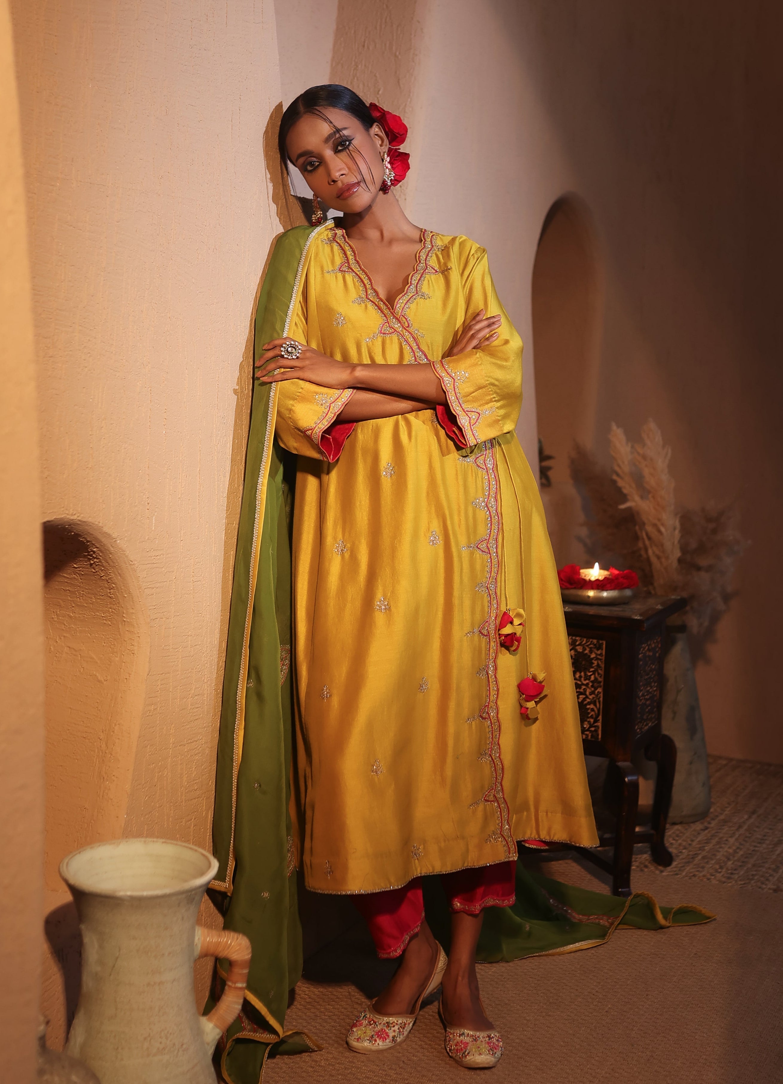 Model wearing a yellow silk chanderi kurta set with green dupatta, red pants with tassel and gold zari aarti taari hand embroidery — festive ethnic outfit.