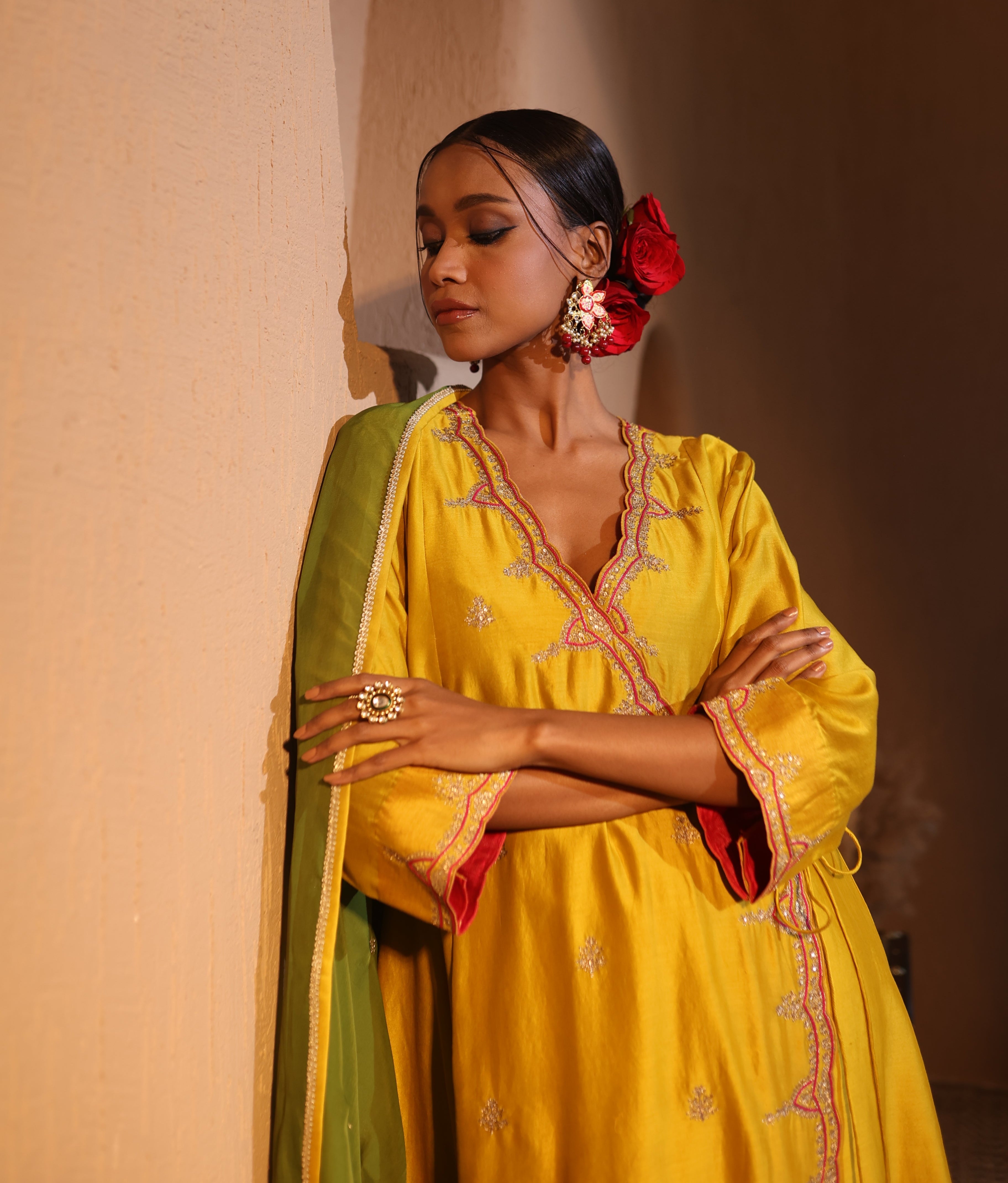 Model wearing a yellow silk chanderi kurta set with green dupatta, red pants, and tassel embroidery — festive ethnic outfit.