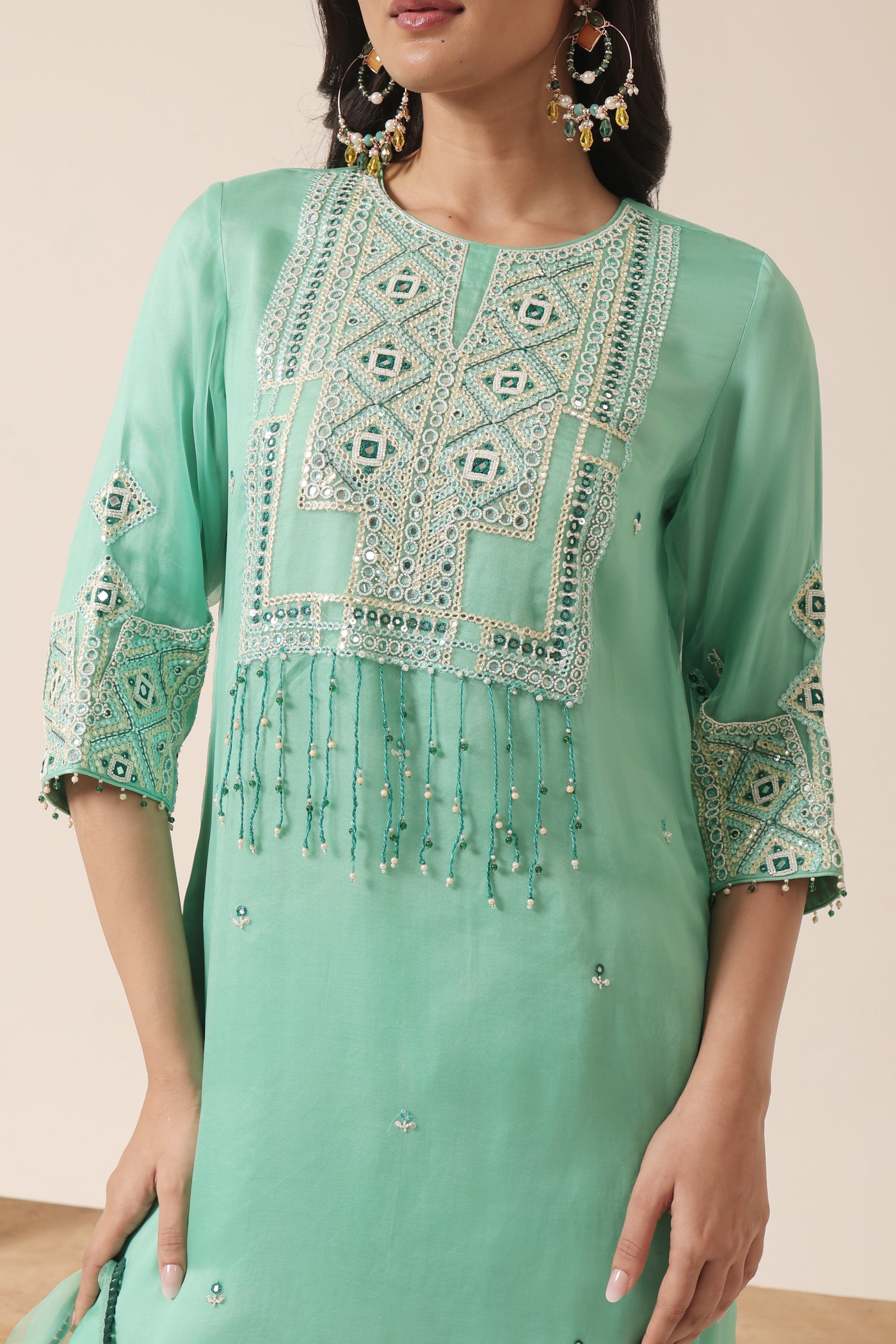 Close-up of mirror embroidery on mint green organza kurta with tassel details – Jhilmil Collection by House of AAS.