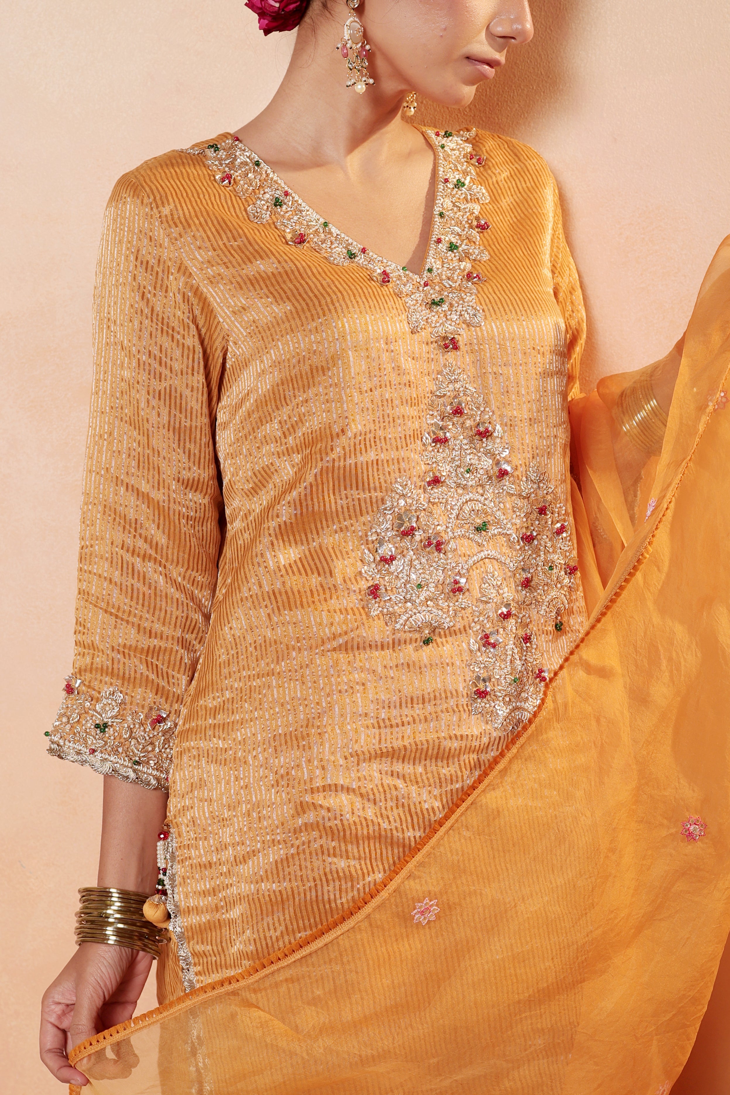 Model wearing orange silk striper tissue kurta with gota embroidery, paired with regal farshi salwar and dupatta – Sunehri Gota Collection by House of AAS.