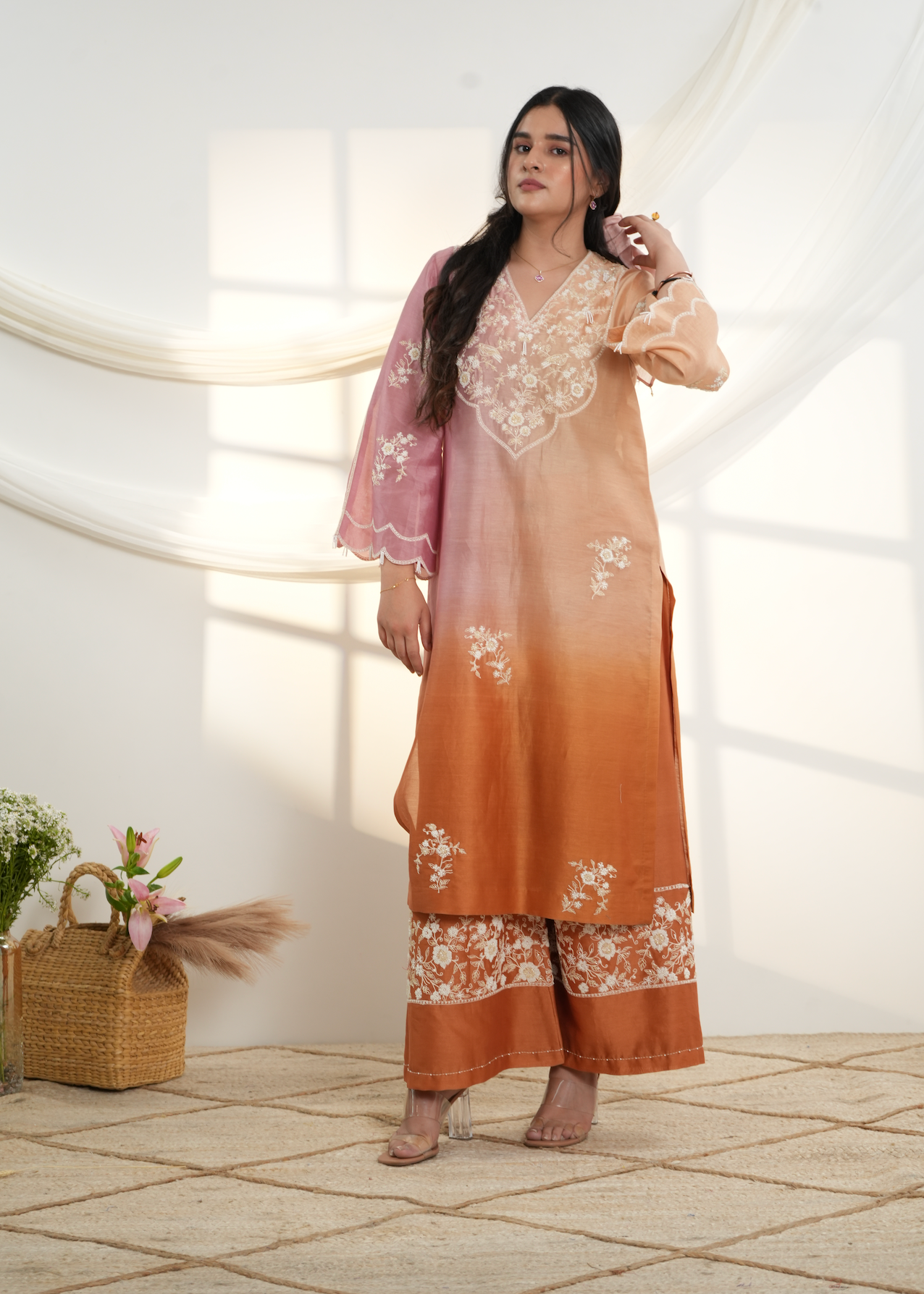 Model wearing a peach & pink ombre silk chanderi kurta set with off-white dori and bead embroidery, styled with floral embroidered wide-leg pants.