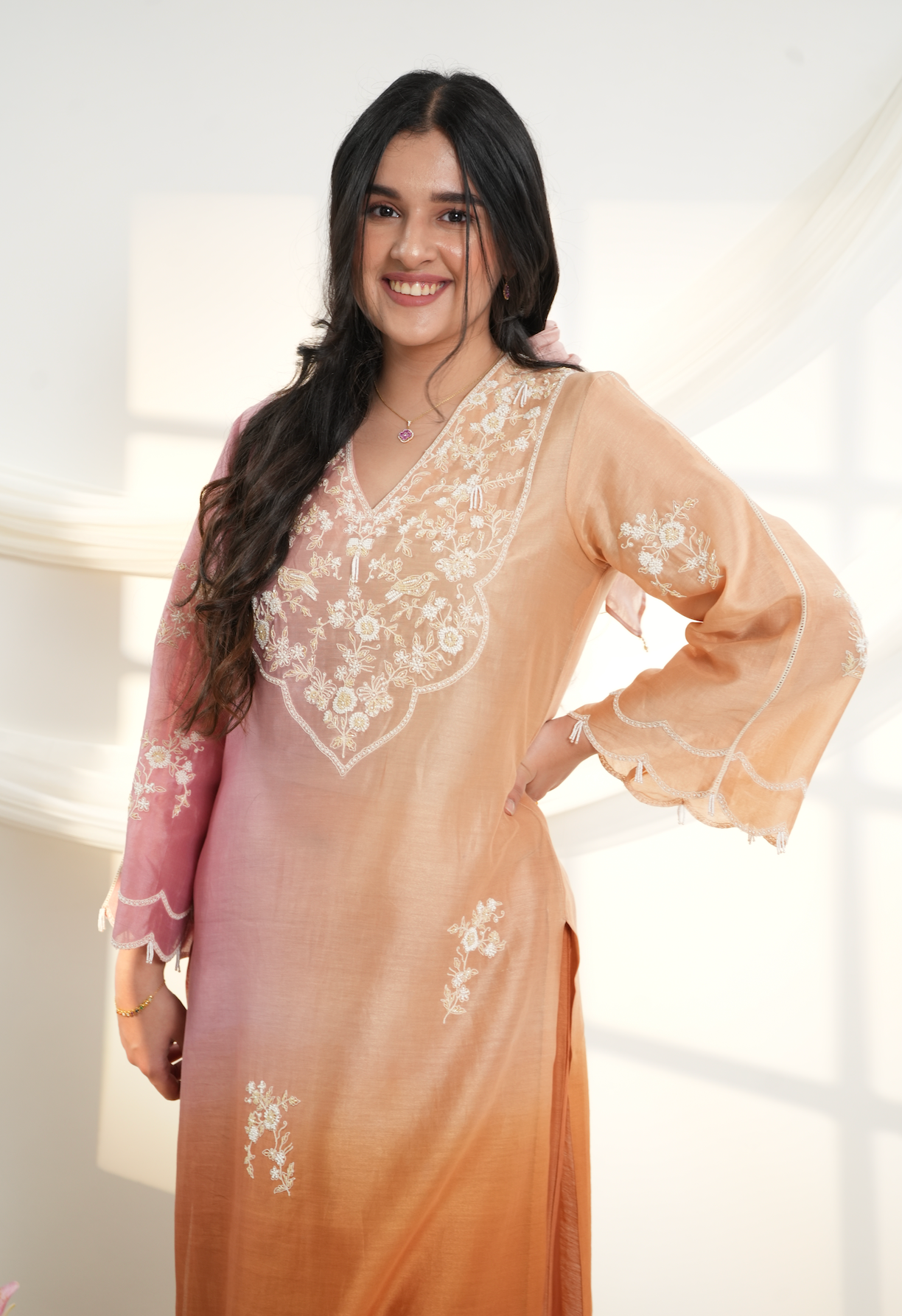 Model wearing a peach & pink ombre silk chanderi kurta set with off-white dori and bead embroidery, styled with floral embroidered wide-leg pants.
