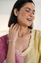 Model wearing a pink, yellow & green ombre silk chanderi kurta set with purple pants and off-white dori bead embroidery — festive ethnic outfit.