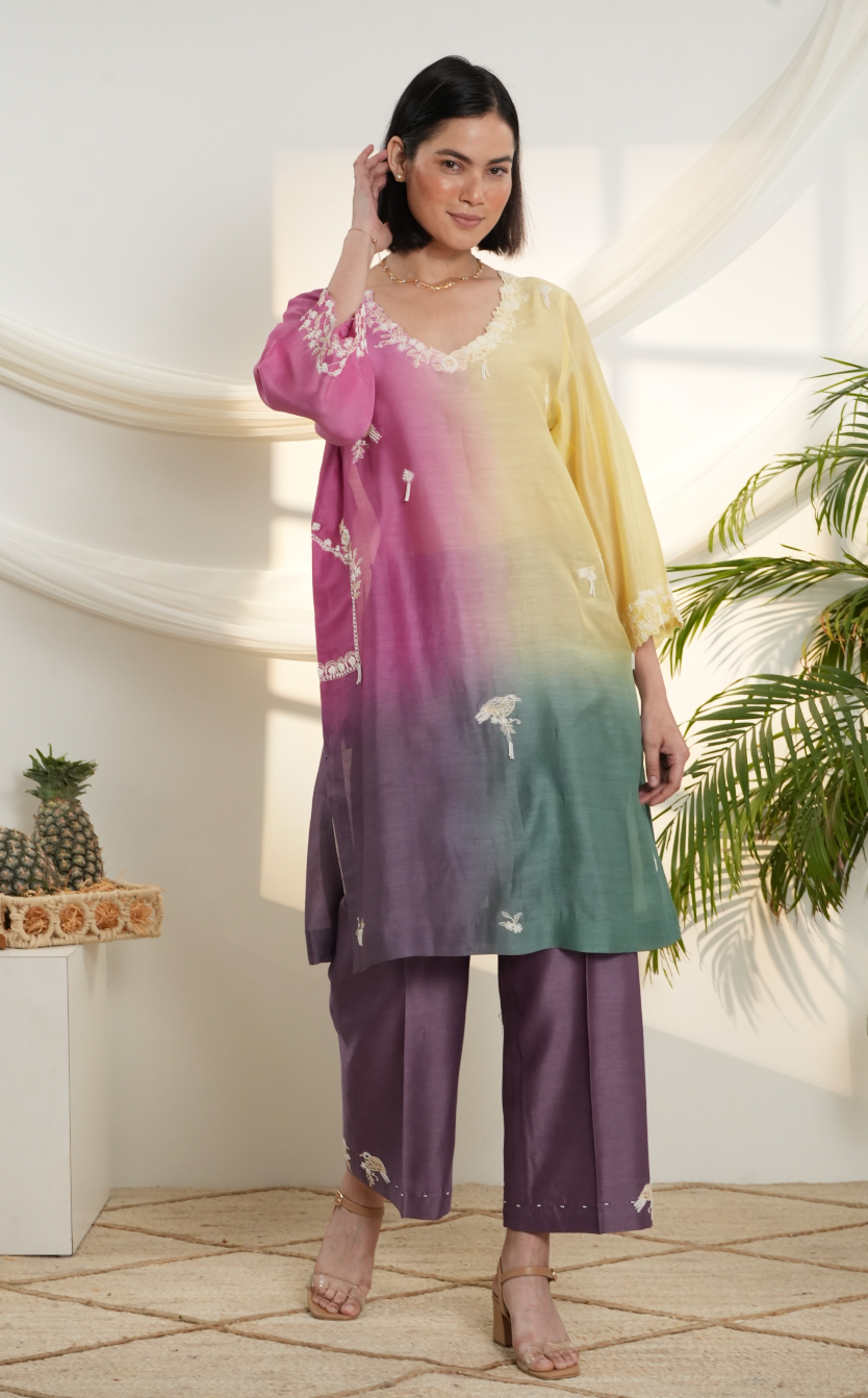 Model wearing a pink, yellow & green ombre silk chanderi kurta set with purple pants and off-white dori bead embroidery — festive ethnic outfit.